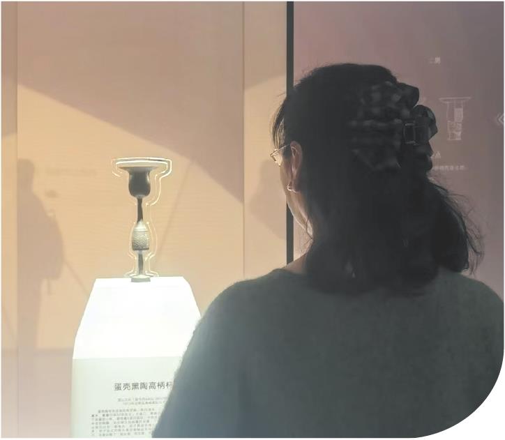 　　参观者“对话”蛋壳黑陶高柄杯