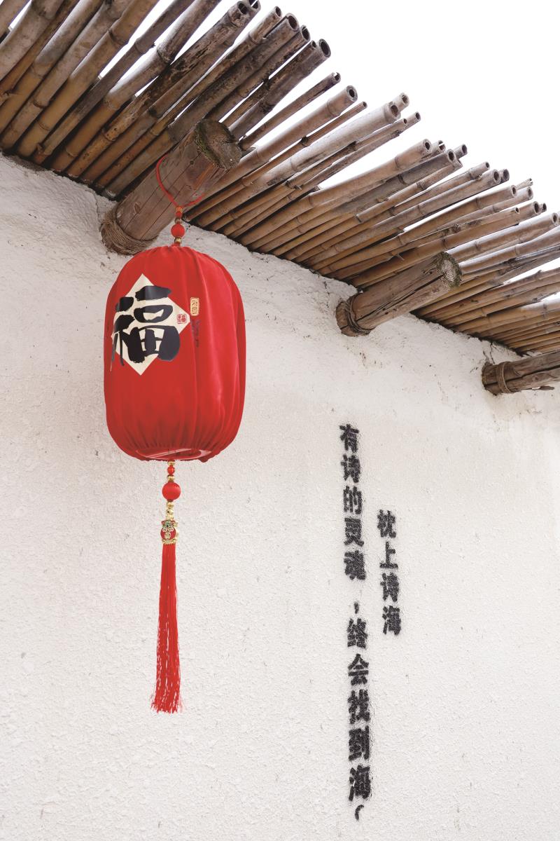 　　枕上诗海民宿里，福字红灯笼悬于白墙，配流苏挂饰，旁有墨书诗句，年味浓郁雅致。