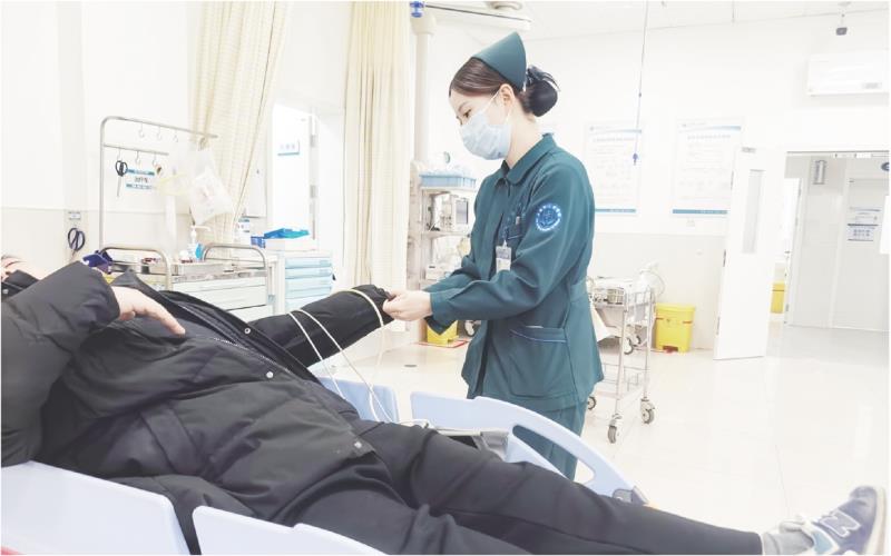 郭长啸为抢救室的患者测量生命体征