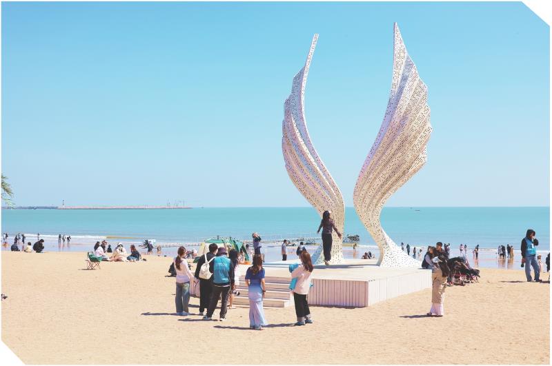 　　全媒体记者　牟善庆　报道
　　4月6日，游客在阳光海岸的“天使之翼”造型前拍照打卡。清明假期，山海天阳光海岸的网红打卡点内，极简风格的建筑与碧海蓝天相映成趣，成为游客定格美好的热门选择。每到一处，游客都会举起相机或手机，选角度、拍美照，用镜头留存春日山海的浪漫瞬间。