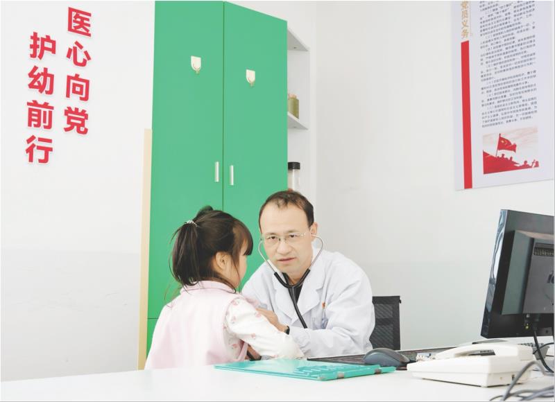 儿科党支部书记卜雷正在为患儿进行诊疗服务